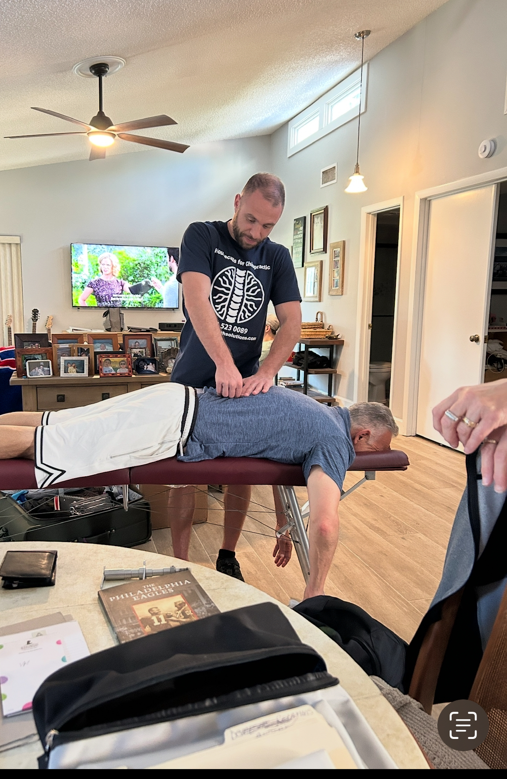 Dr. Yale Gordon delivering a chiropractic adjustment on a portable table in a patient's home